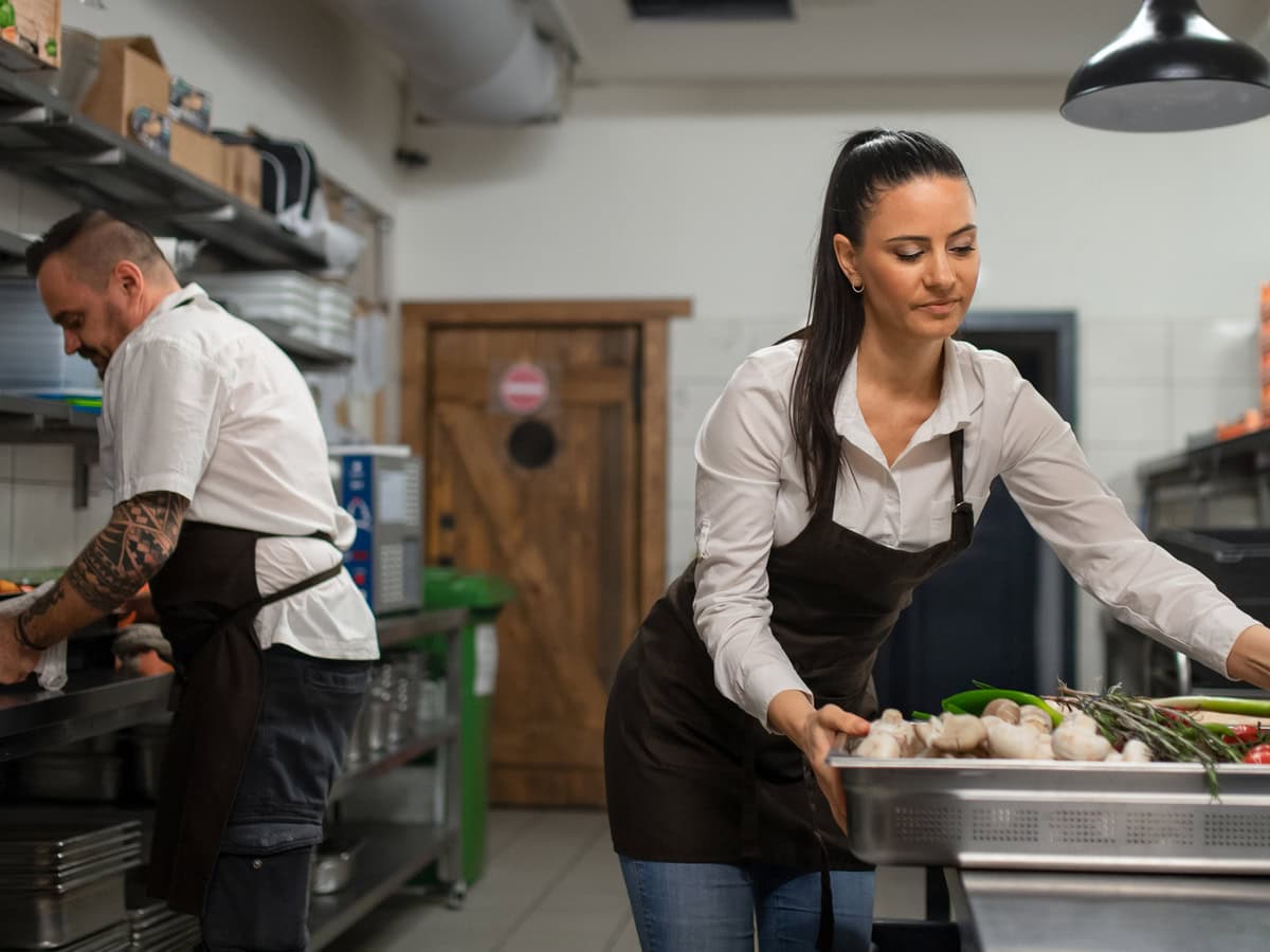 chef and cook working on their dishes indoors in restaurant kitchen.