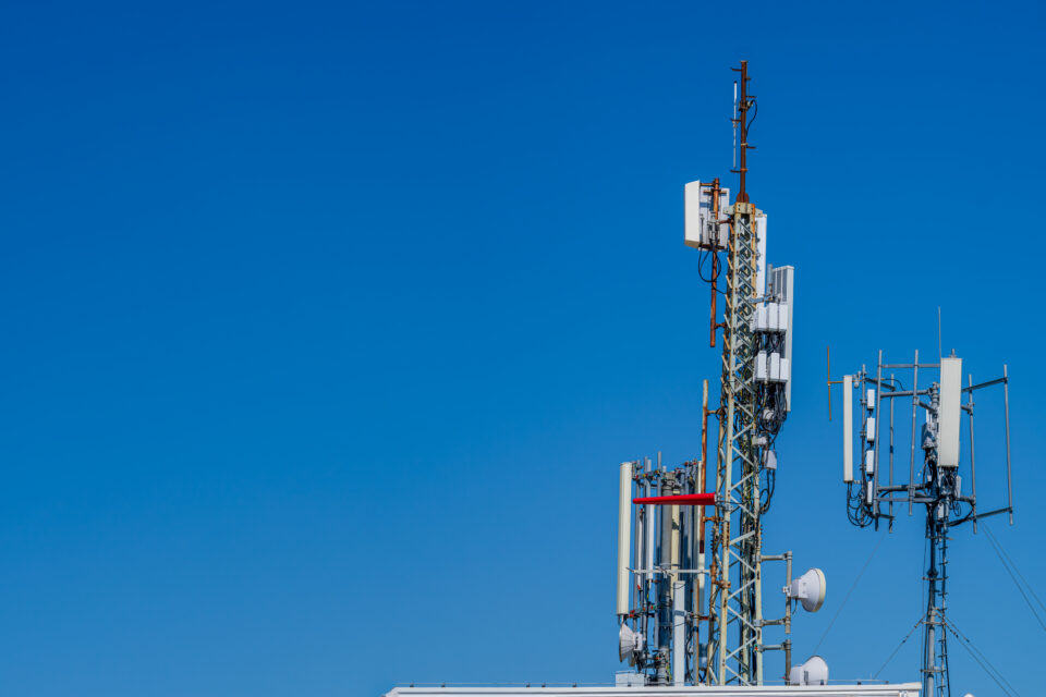 5G infrastructure revenue maximization. Cell tower against a blue sky