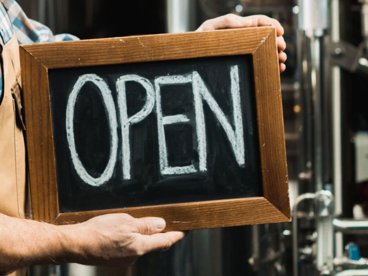cropped view of owner holding board with open sign 2026 01 06 00 38 51 utc scaled