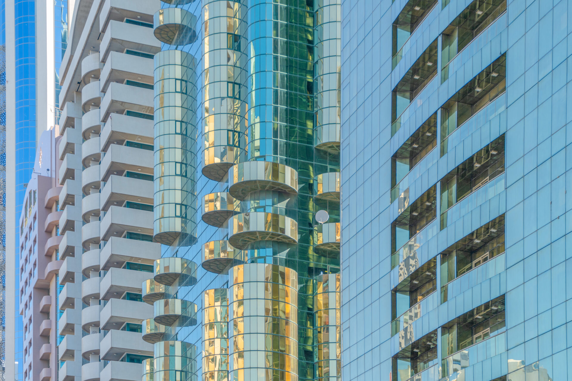 Looking up to high-rise office buildings, skyscrapers, architectures in financial district with blue sky. Smart urban city for business and technology concept background in Downtown Dubai, UAE.
