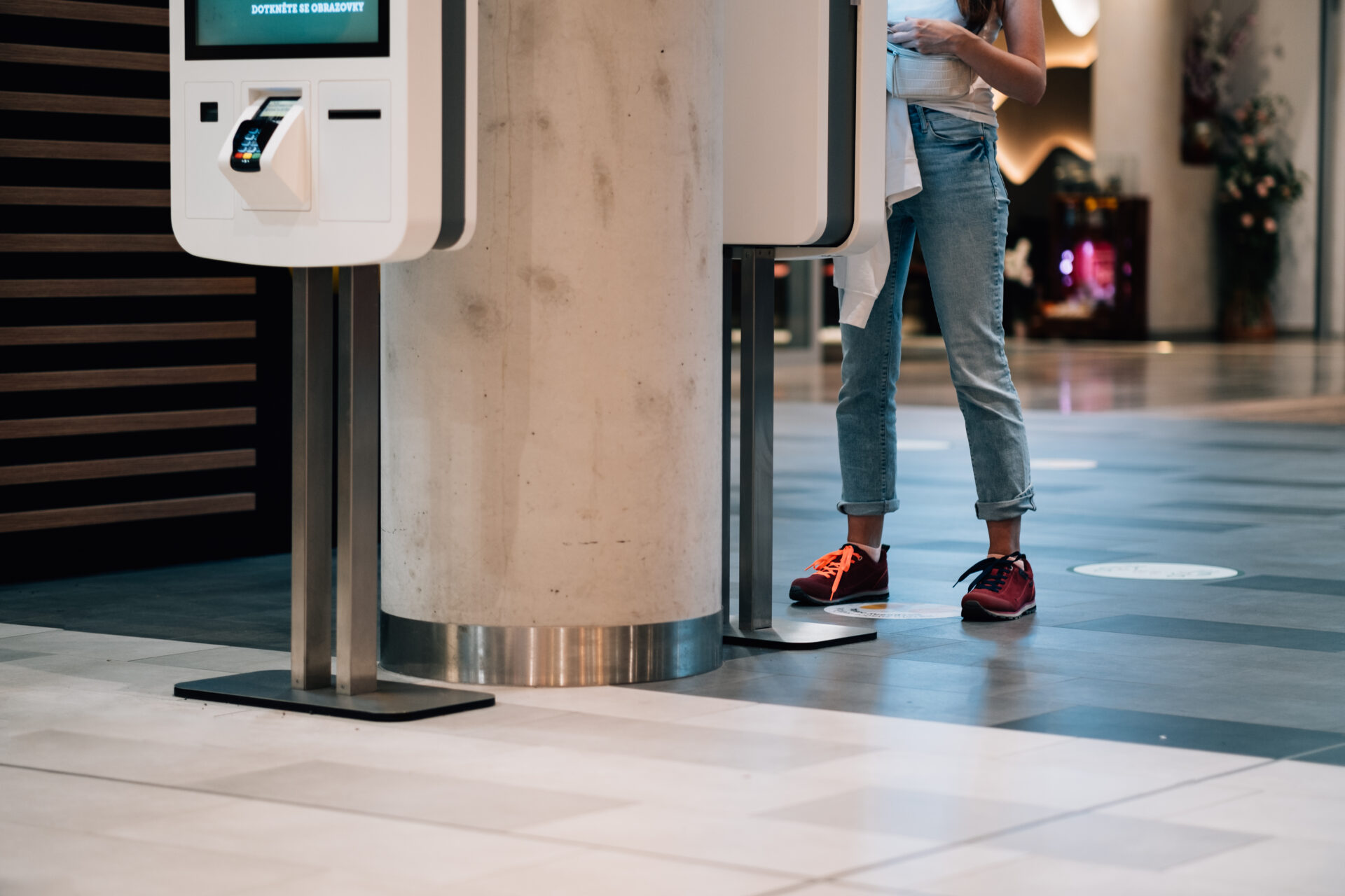 Touchless technology financial impact. A woman using a cashless payment kiosk