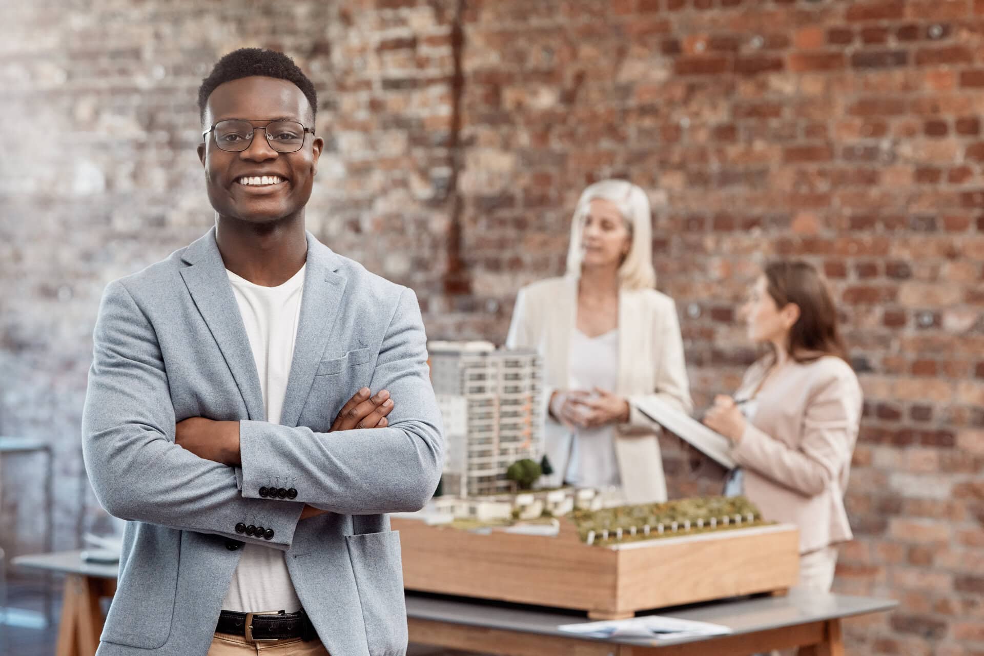 Happy, smiling and expert business man standing with arms crossed while working in an office at wor.