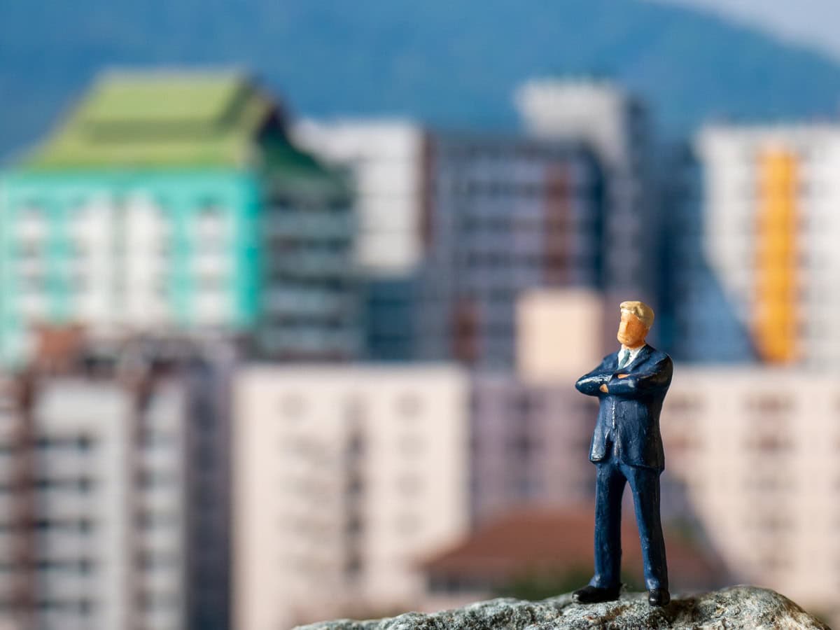 miniature people businessman standing on the roc 2026 03 26 07 27 59 utc