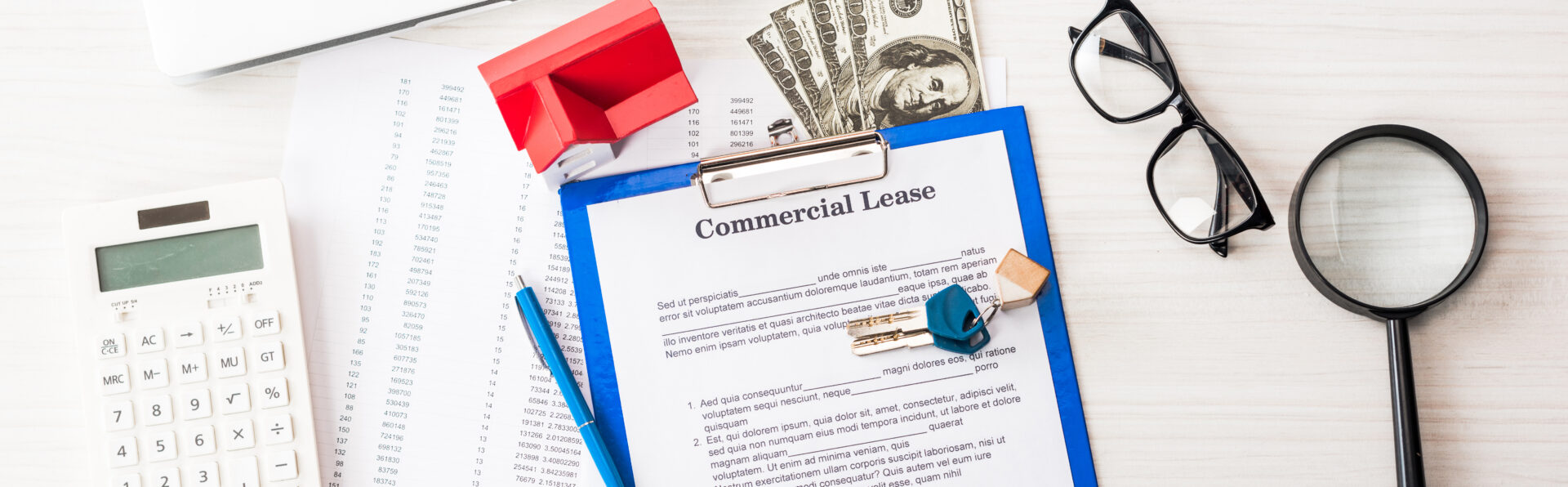 panoramic shot of document with commercial lease lettering on clipboard near keys, house model, pen