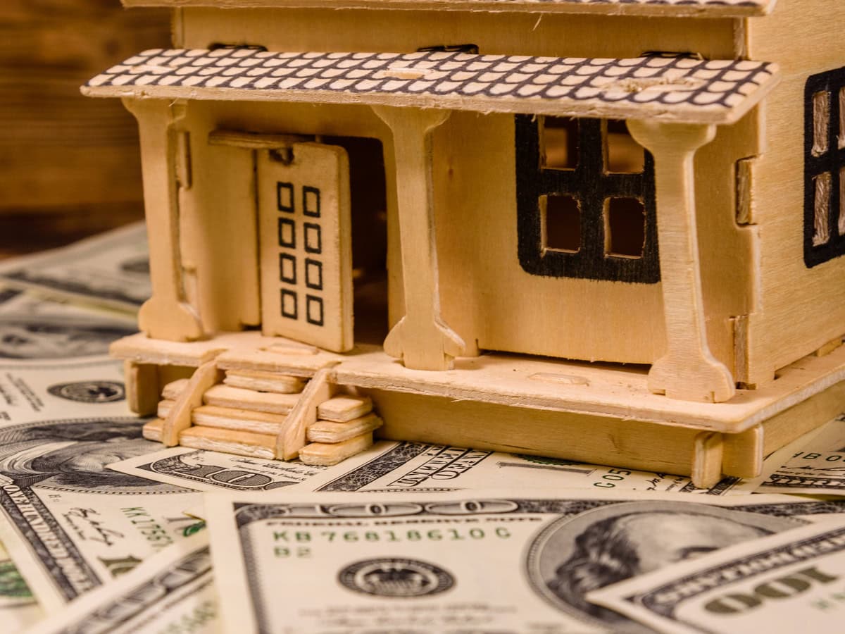 plywood model of house and one hundred dollar bank 2026 03 26 04 43 43 utc