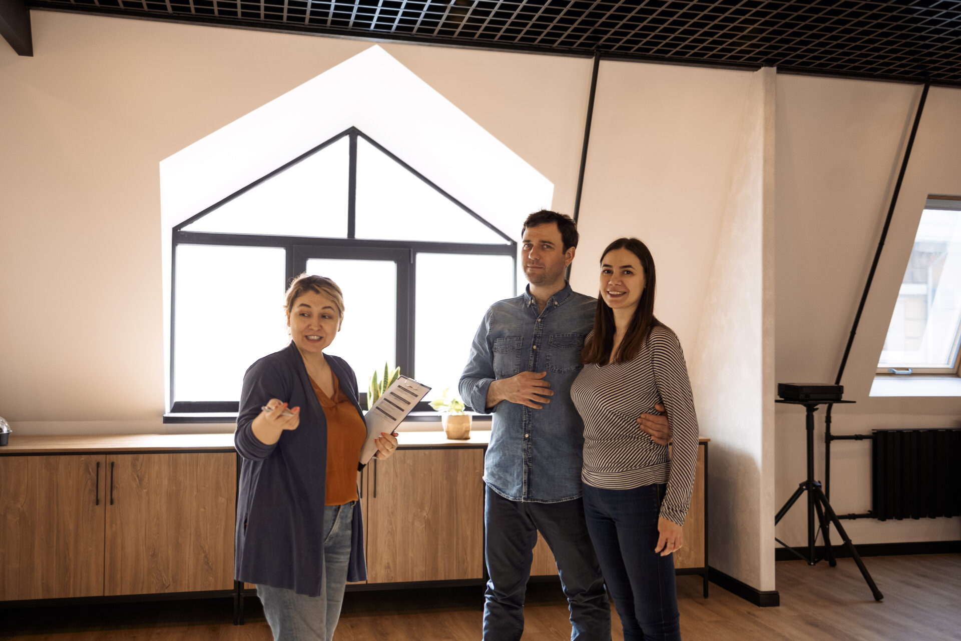 real estate agent with young couple in new apartment
