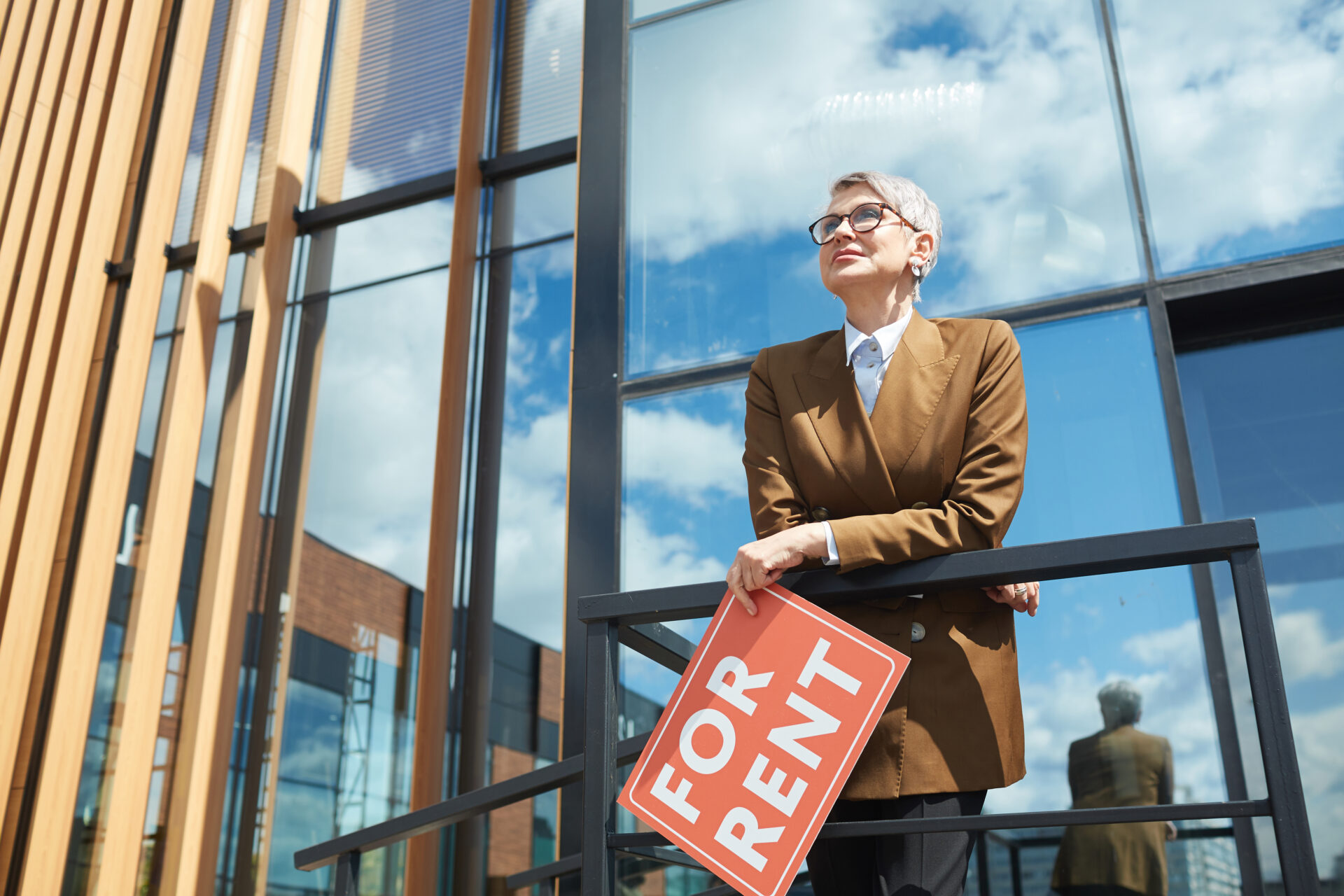 Mature businesswoman in eyeglasses working as a realtor at modern office building